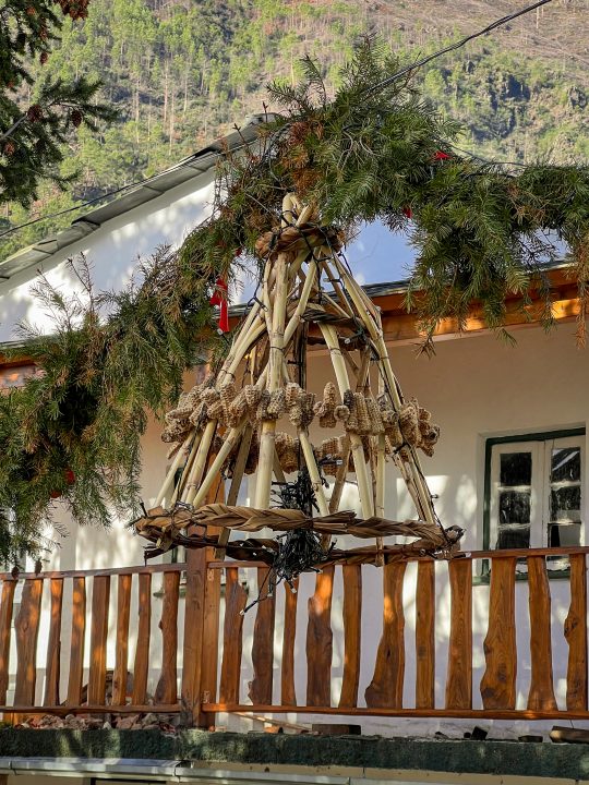 Handmade bamboo chandelier decorated with pinecones and natural materials in Cabeça