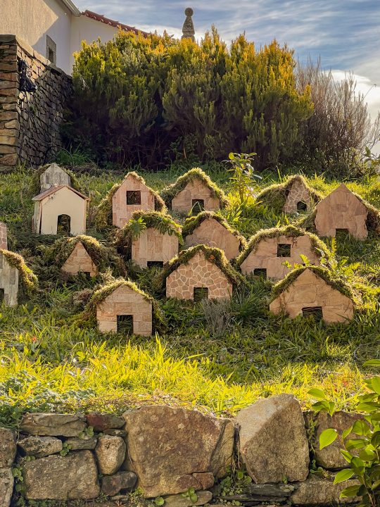 Decorative moss-covered miniature houses made from stone and natural materials in Cabeça
