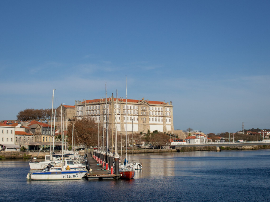 Hilltop monastery overlooking marina with moored sailboats below