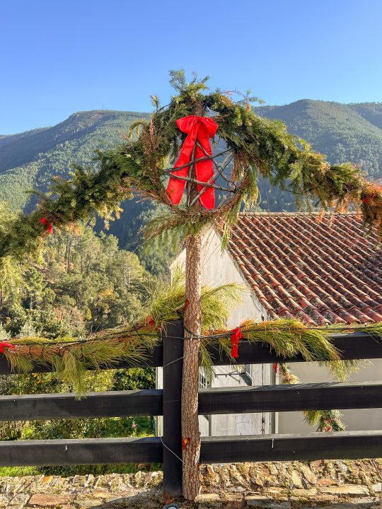 Natural Christmas wreath with red bow against Serra da Estrela mountain backdrop