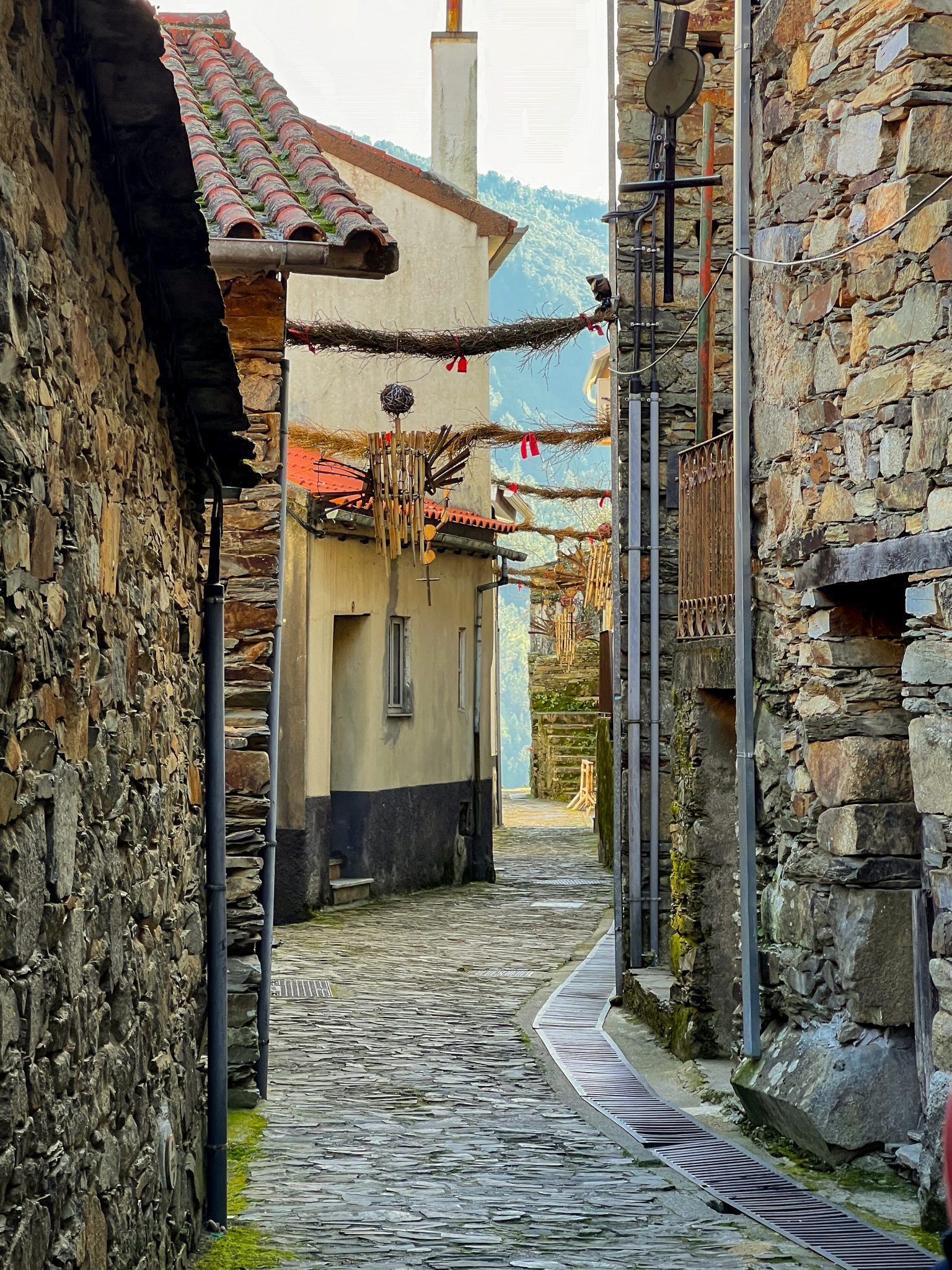 Streets of Cabeça Village Narrow cobblestone street with traditional stone houses decorated for Christmas in Cabeça