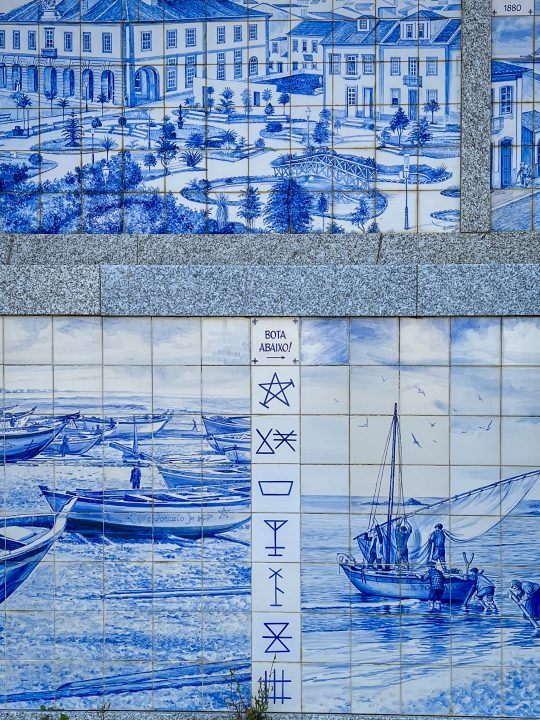 Traditional siglas poveiras symbols painted on blue and white Portuguese azulejos